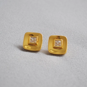 Macro detail of 18K gold plated square earrings with sparkling cubic zirconia stone center