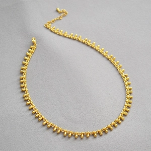 Elegant gold brass drop necklace featuring minimalist water droplet pendants on thin chain