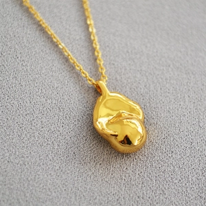 Elegant gold brass necklace featuring a polished baroque style abstract molten lava pendant