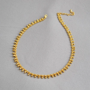 Detail of gold teardrop necklace featuring small water drop charms and lobster clasp