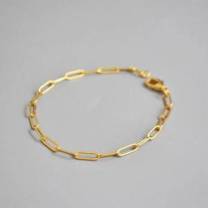 Minimalist gold-plated rectangle link chain bracelet with lobster clasp on grey background