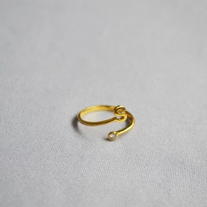 Detail of adjustable gold ring featuring an S initial and a sparkling round white zircon