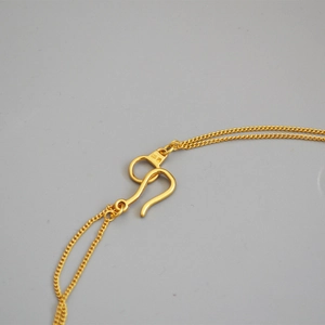 Macro view of gold double-layer chain necklace featuring S-hook clasp and 999 hallmark