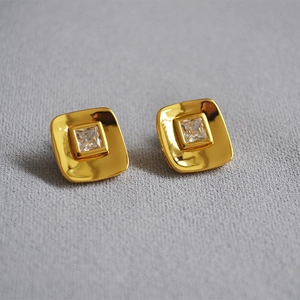 18K gold plated square stud earrings with central cubic zirconia on a gray background