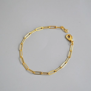 Close-up of polished gold-plated paperclip chain bracelet with secure lobster clasp closure