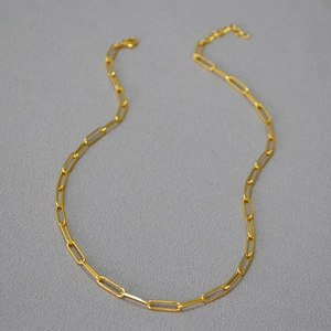 Detail view of golden paperclip chain necklace with lobster clasp and extension link