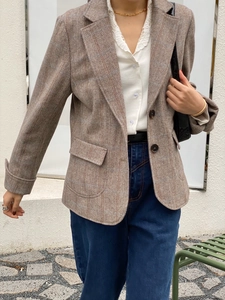 Détails du blazer marron à chevrons avec revers à encoche et poches à rabat élégantes