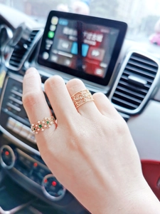 Detail of vintage gold lace ring with emerald and pearl stacking set on finger