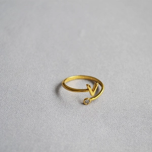 Detail of adjustable gold ring with letter V and a sparkling round cubic zirconia