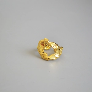Detailed view of the irregular lava texture and gold-tone finish on the modern open ring