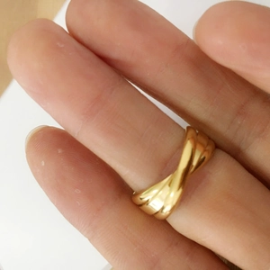 Close-up of a gold triple-layer interlaced ring worn on the finger for a minimalist look