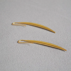 Detailed view of polished gold teardrop earrings with minimalist curved design