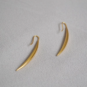 Detailed view of gold plated brass teardrop earrings with a smooth polished finish