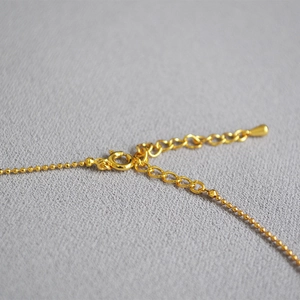 Minimalist gold faceted bead necklace featuring a secure spring clasp and extension chain