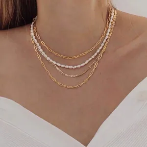 Layered gold necklace set with paperclip chain, white pearls and a Y-shaped heart pendant