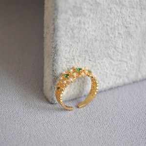 Vintage emerald and pearl open ring in gold lace engraving style on grey velvet