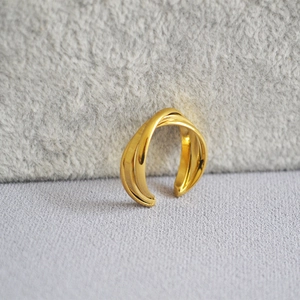 Detailed macro view of the double-layered interlocking gold brass ring with mirror polish