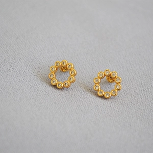Detailed macro shot of gold-plated wreath earrings with micro-set sparkling cubic zirconia
