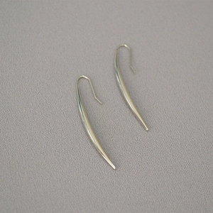 Macro view of silver-plated horn-shaped earrings with polished metallic minimalist finish