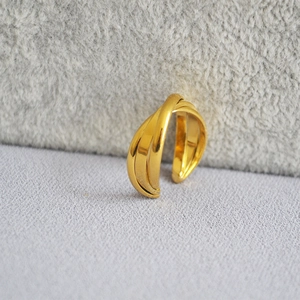Detailed macro shot of 18k gold plated triple-layer criss-cross ring with smooth finish