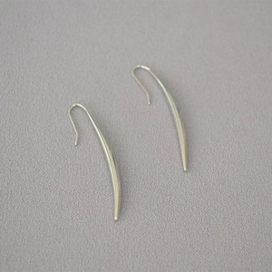 Polished silver curved horn earrings showing a minimalist arc design and high-gloss finish