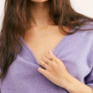 Minimalist gold alphabet rings with cubic zirconia stones worn on model's fingers