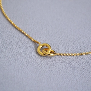 Elegant gold double-interlocking ring necklace with polished finish on O-chain