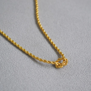 Élégant collier chaîne en corde torsadée dorée avec un détail de nœud décoratif
