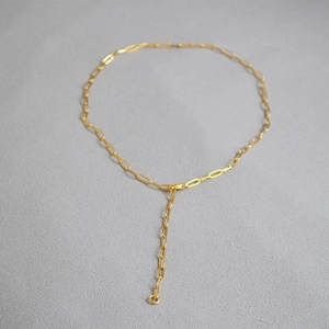 Detailed view of golden paperclip chain necklace with a Y-shaped drop and lobster clasp