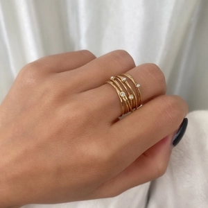 Close-up of handmade gold multilayer ring with crystal accents on a model's hand