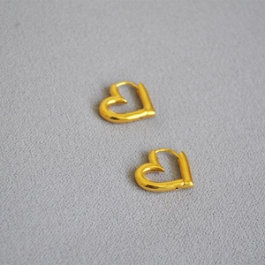Détail de boucles d'oreilles cœur évidé plaqué or avec finition polie et fermoir cliquet