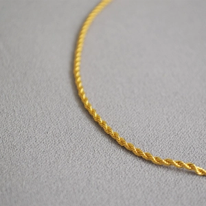 Vue macro d'une chaîne corde dorée brillante avec texture de métal torsadé
