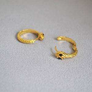 Snake hoop earrings in gold finish featuring black zircon eyes and scale texture