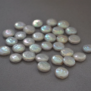 Macro shot of high-luster baroque button freshwater pearls on textured fabric