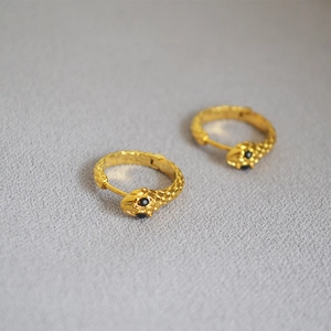 Minimalist gold snake hoop earrings with black gemstone eyes and textured scales