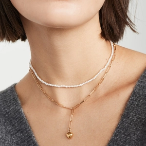 Layered jewelry set with white pearl choker and gold heart pendant on paperclip chain necklace