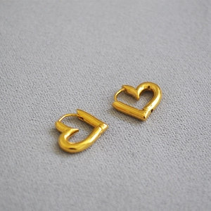 Vue macro des boucles d'oreilles créoles cœur évidé avec placage en or sur laiton