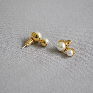 Detail view of peanut-shaped double pearl earrings with elegant gold-tone 925 silver studs