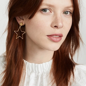 Retro hollow star gold drop earrings in 925 silver shown on a model on a grey background