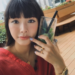 Polished gold-plated bamboo joint ring shown on a hand in an outdoor lifestyle setting
