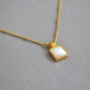 Collier vintage avec pendentif carré en nacre sur une chaîne en laiton doré chic