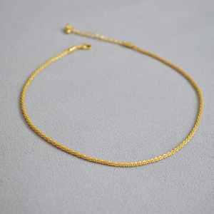 Close-up of 18k gold plated choker featuring a sparkling twisted star-dust chain design