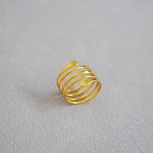 Close-up of a handcrafted multi-layer spiral ring with polished gold-plated finish
