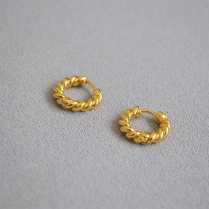 Détail des boucles d'oreilles créoles torsadées plaquées or 18 carats avec texture polie