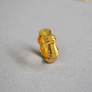 Macro detail of high-polish gold plated brass ring with unique bamboo joint texture