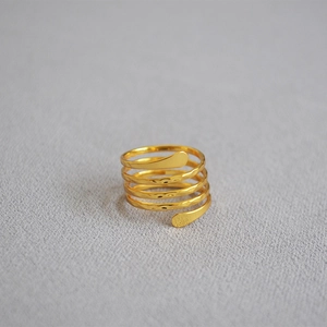 Detail of multi-layer spiral ring featuring a golden hammered texture and open band design