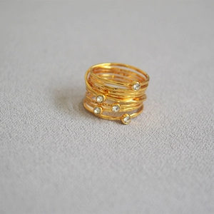 Detailed view of layered gold rings with hammered texture and inlaid cubic zirconia