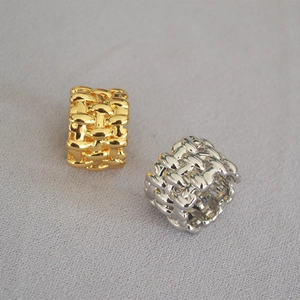Macro detail of gold and silver plated woven mesh wide band rings with mirror finish