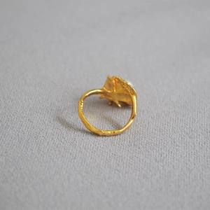 Detailed macro view of vintage gold rose leaf ring with pearl and textured finish