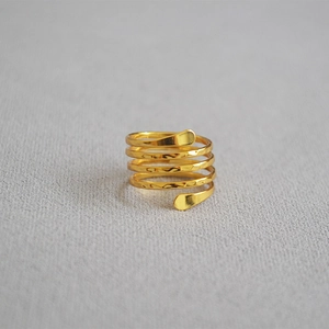 Macro detail of gold multi-layer wrap ring featuring unique hand-hammered texture finish